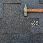 Hammer and nails on a shingle roof