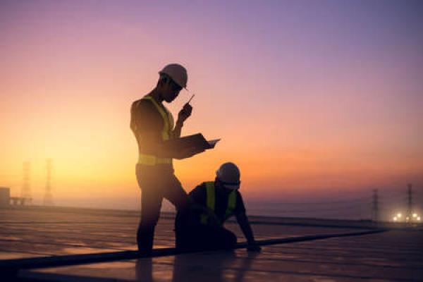 Two technicians service a commercial roof