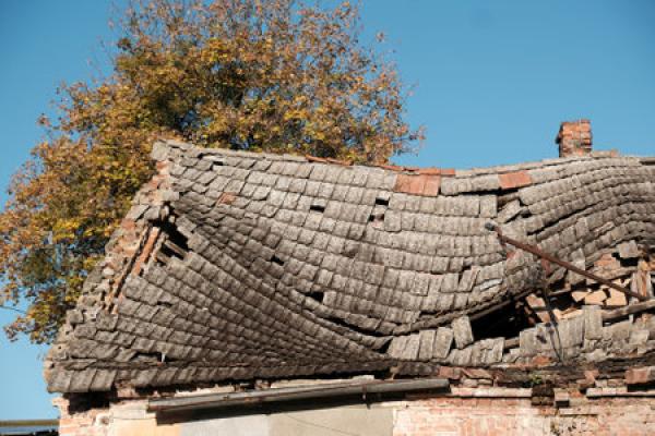 A tile roof is so damaged that it's sinking into a house