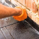 A man applying a coating to a roof